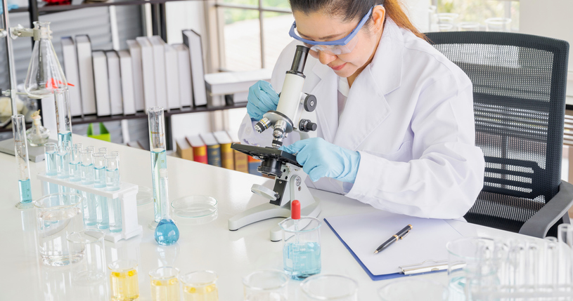 asian female scientist analyzing sample in laboratory. medical professional is experimenting.